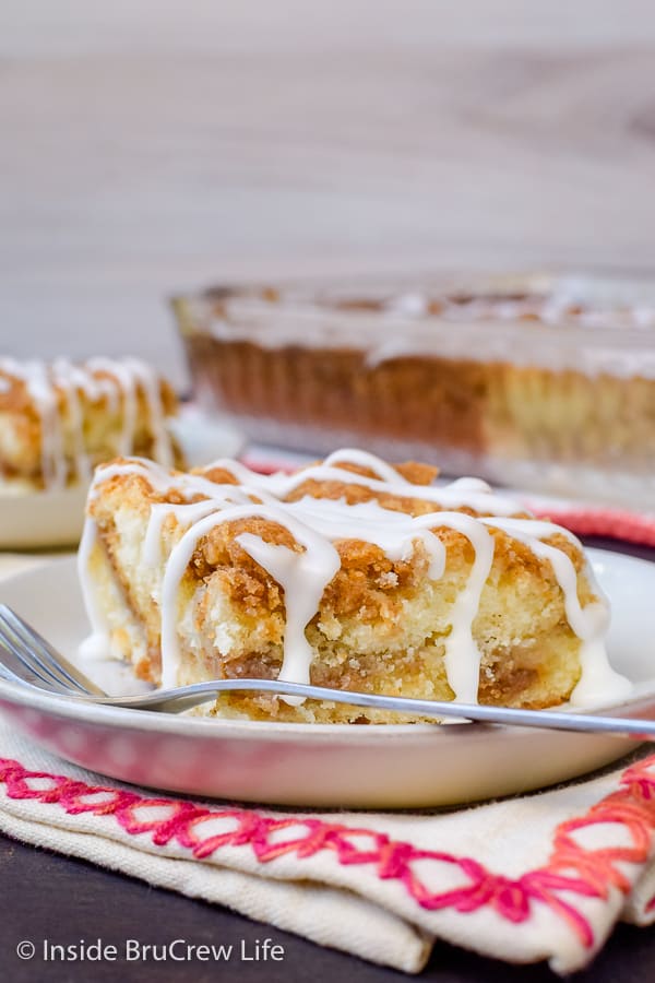 A slice of sour cream coffee cake with a sweet sugar glaze drizzled on top.