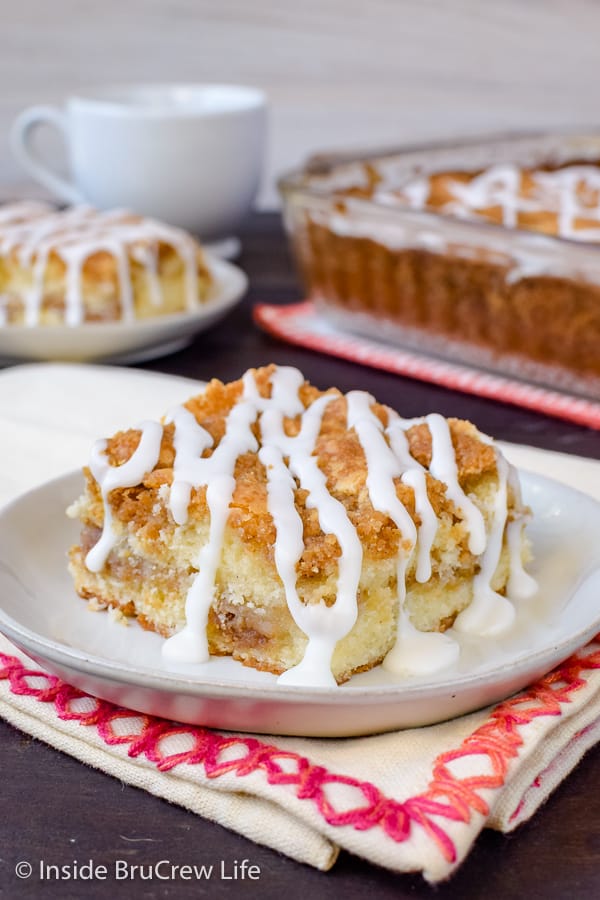 Two plates with squares of coffee cake with glaze drizzled on top.