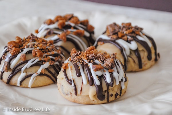 A white plate with shortbread toffee cookies topped with brown sugar glaze and chocolate drizzles.