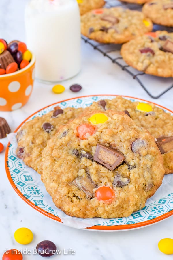 A plate on a white board with three peanut butter oatmeal banana cookies on it