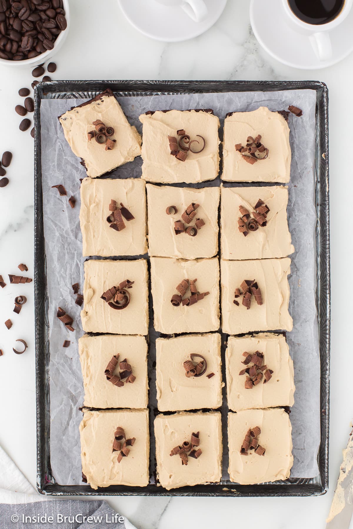 A sheet pan with squares of coffee brownies on it.
