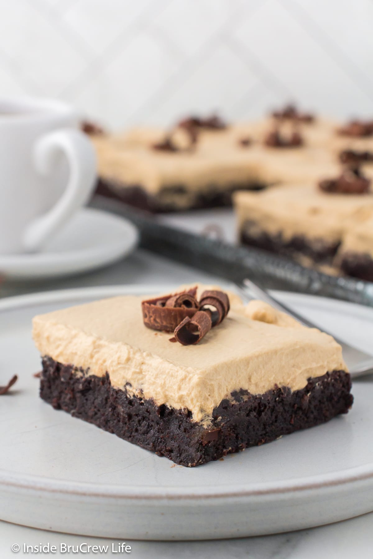 A mocha brownie topped with coffee frosting on a plate.