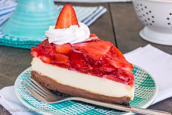 A slice of strawberry chocolate cheesecake on a teal and white plate