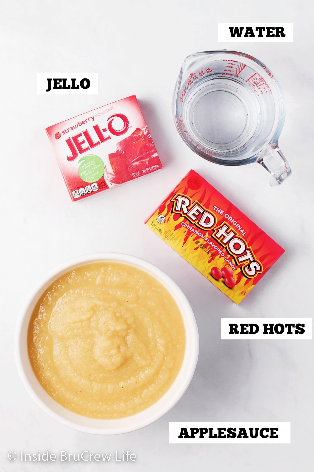 A white board with bowls of ingredients for a cinnamon red Jello.