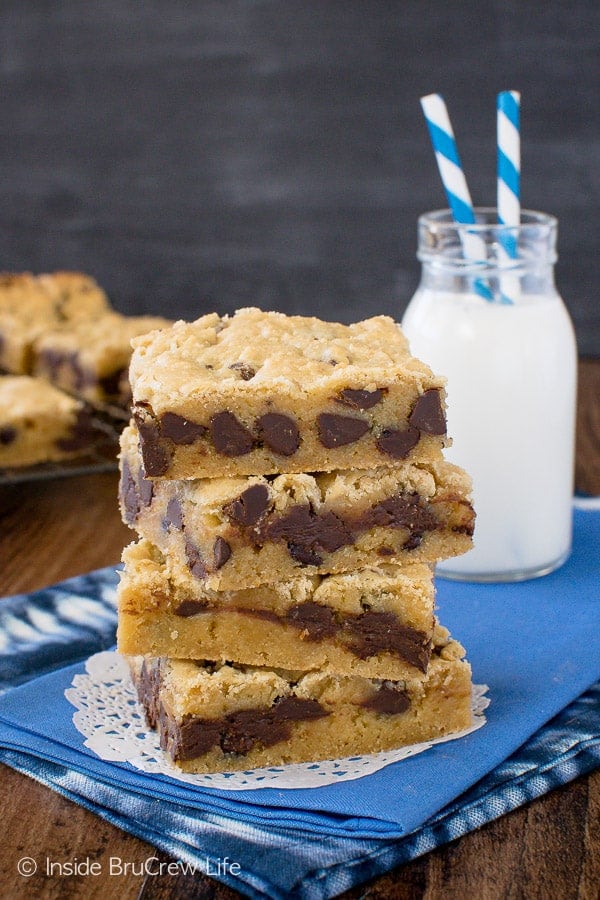 A stack of four chocolate chip cookie bars on a blue towel.