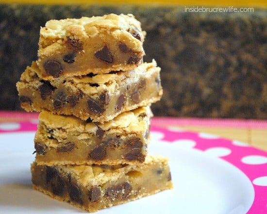 A stack of four chocolate chip cookie bars stacked on a plate.