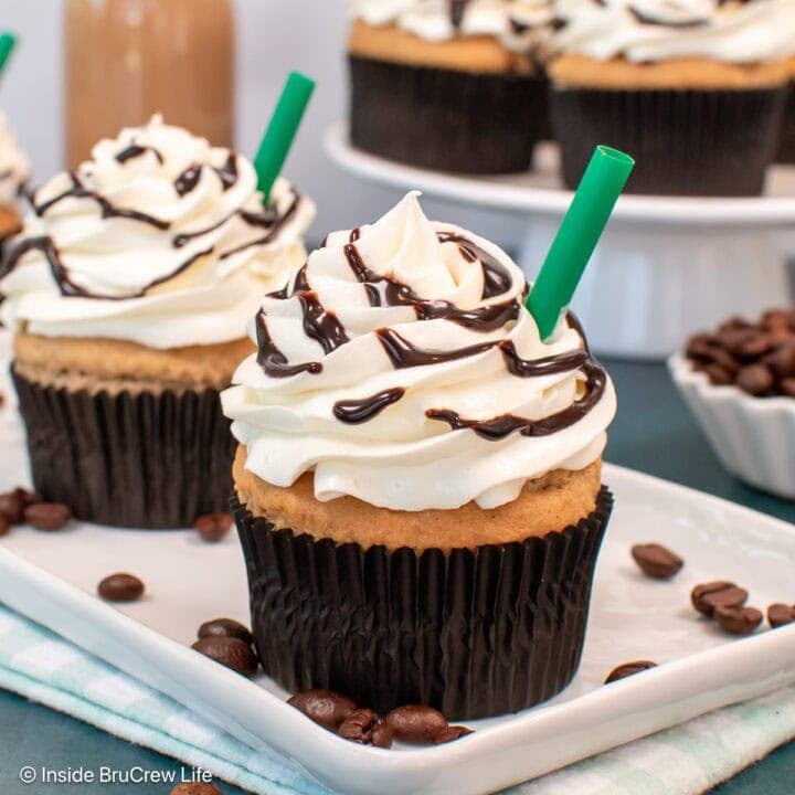 Two frosted cupcakes on a white tray.
