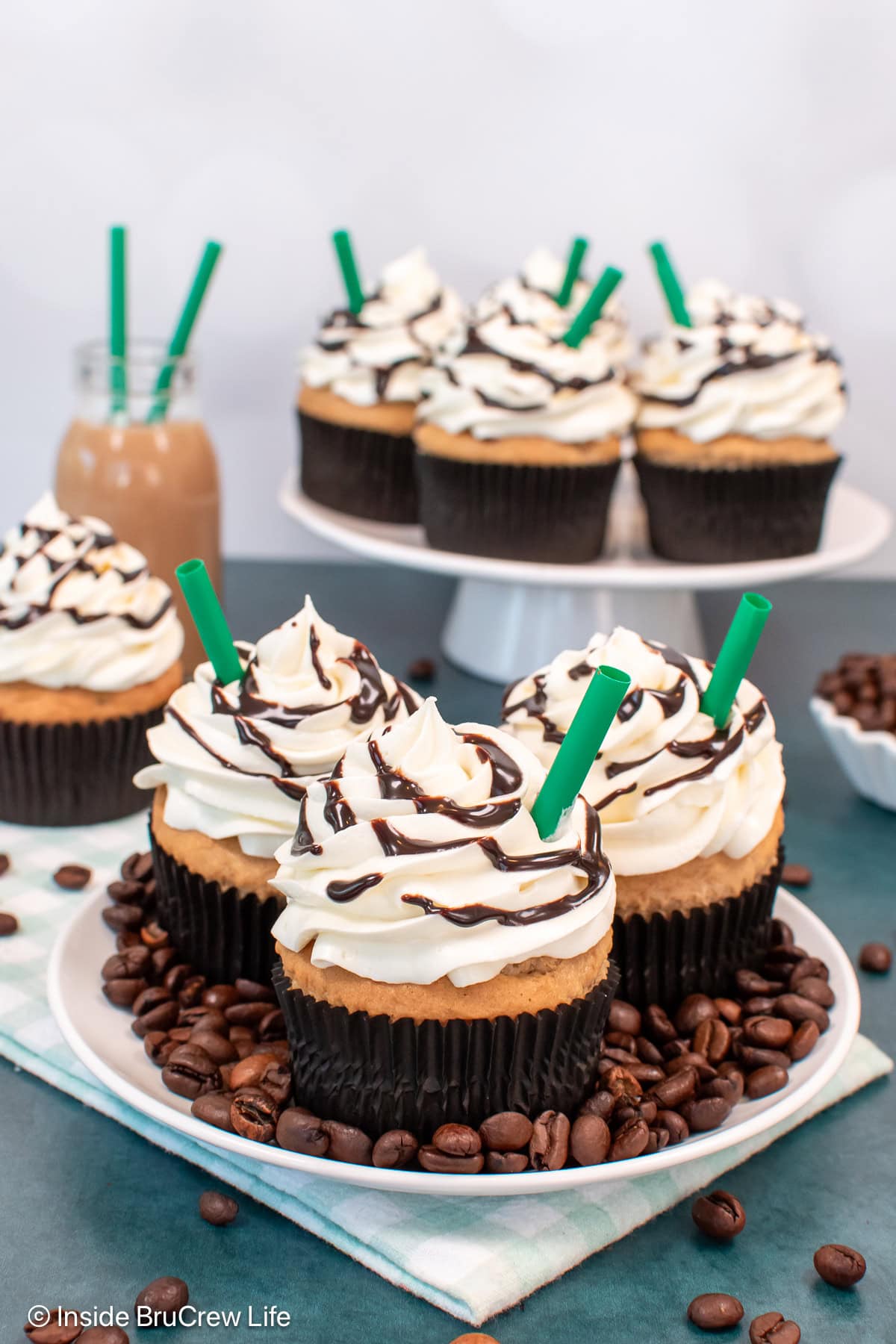A plate with coffee beans and frappuccino cupcakes on it.