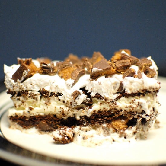 A slice of ice cream cake topped with peanut butter candies.