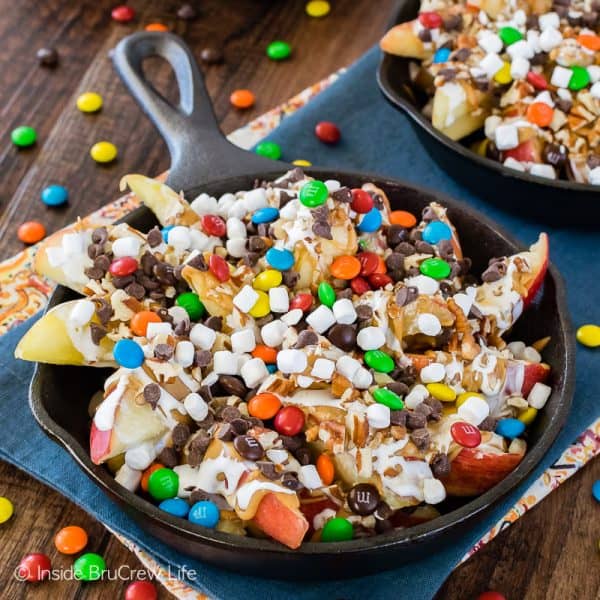 Apple Nachos - apple slices topped with caramel, peanut butter, marshmallow, candy, and chocolate chips! Make a big plate of these apples to enjoy as an after school snack! #apples #nachos #healthysnack #nobake #fall #recipes #easy 