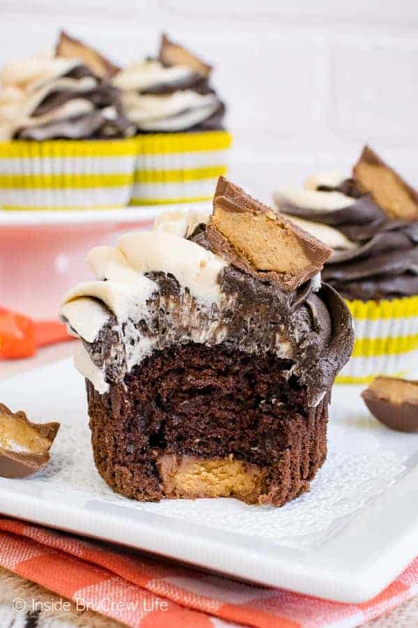 Reese's Chocolate Peanut Butter Cupcakes - the hidden candy bar and swirled chocolate peanut butter frosting makes these cupcakes disappear in a hurry. Make this easy recipe for parties! #cupcakes #chocolate #peanutbutter #reeses #peanutbuttercups #frosting