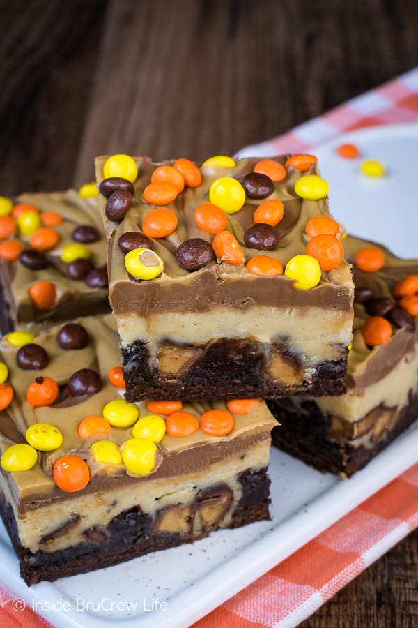 A white tray with squares of peanut butter cheesecake brownies on it.