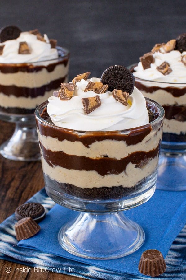 Three parfait cups filled with peanut butter pie filling and chocolate ganache.