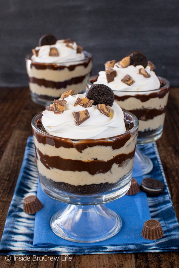 Three glass cups filled with peanut butter and chocolate layers.