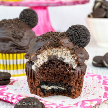 A chocolate cupcake with an Oreo in the bottom and cookies and cream frosting dipped in chocolate