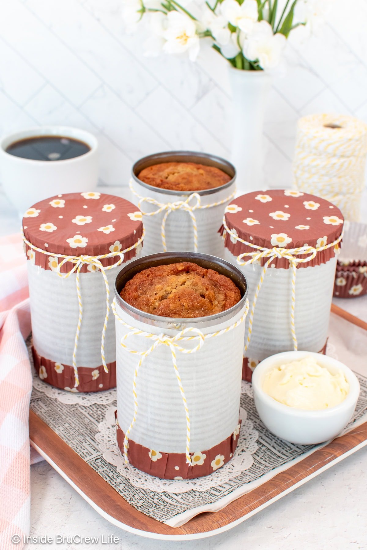 Four cans on a tray with baked banana bread in them.