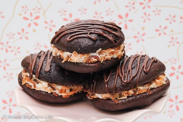 Three mocha coconut whoopie pies stacked on a pink plate.