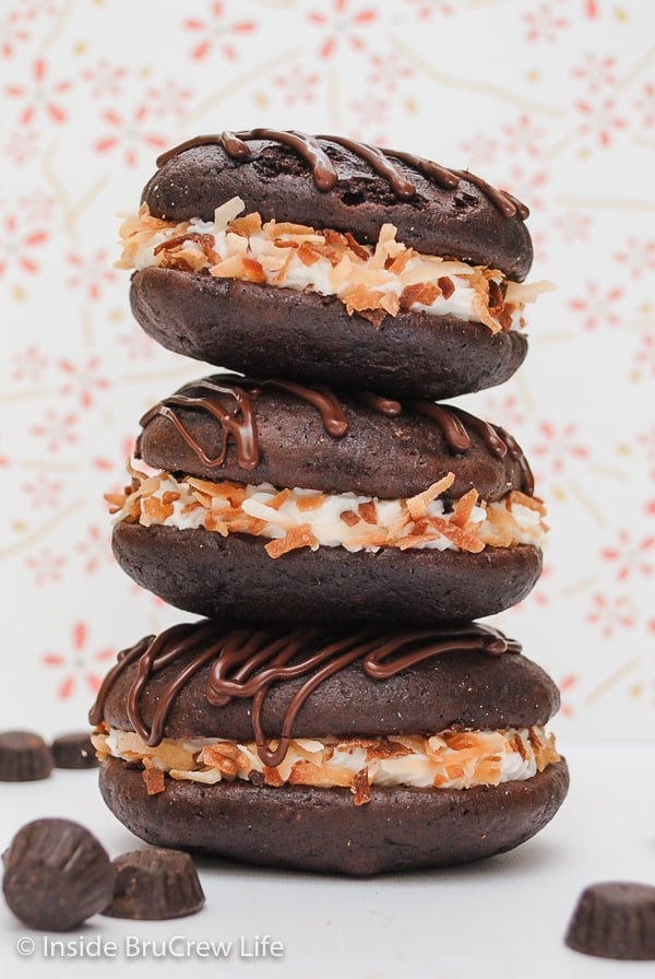 Three chocolate whoopie pies filled with coconut frosting and rolled in toasted coconut.