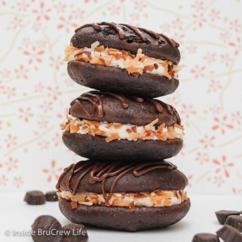 Three chocolate whoopie pies filled with coconut frosting and rolled in toasted coconut.