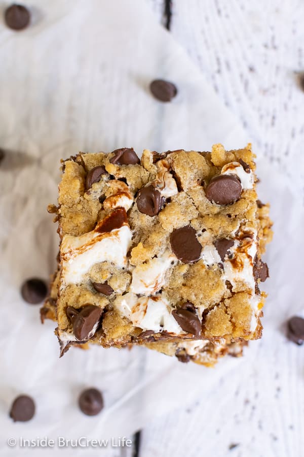 An overhead shot of a square Peanut Butter S'mores Blondie on a white background