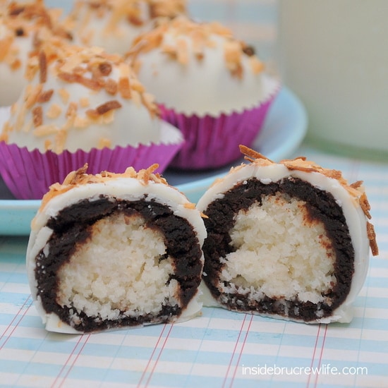 A Coconut Macaroon Brownie Bite cut in half to reveal the chocolate and coconut layers.
