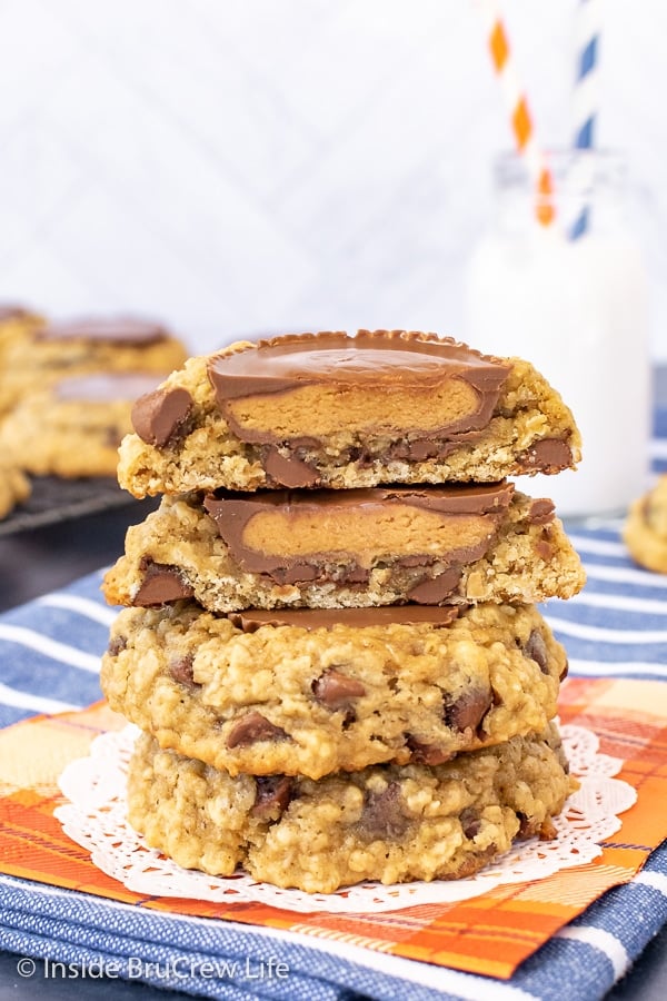 Three oatmeal banana cookies stacked on top of each other with the top one cut in half showing the peanut butter cup inside