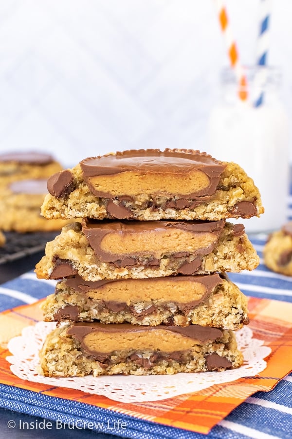 Four oatmeal banana cookie halves stacked on top of each other showing the inside of the peanut butter cup that is on top of them