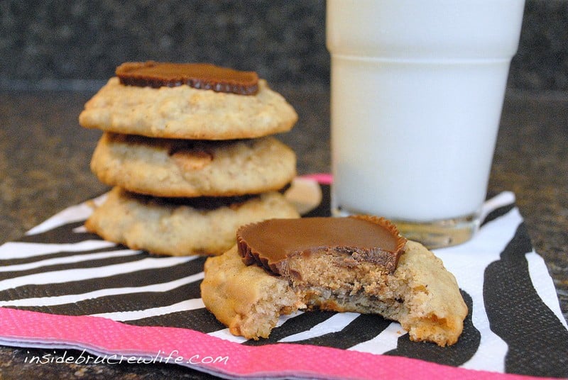 An oatmeal banana cookie topped with a peanut butter cup with a bite out of it on a napkin