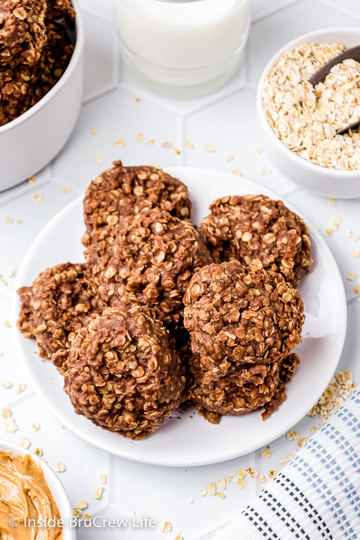 A white plate with a stack of chocolate oatmeal drop cookies on it.