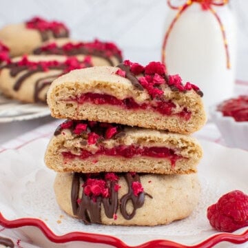 Raspberry filled cookies on a white plate.