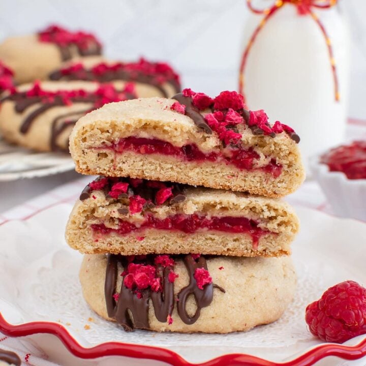 Raspberry filled cookies on a white plate.