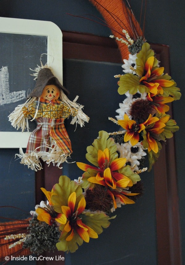 Easy DIY Fall Wreath - yarn, silk flowers, a scarecrow, and a mini chalkboard make this easy fall wreath the perfect craft for your front door #wreath #craft #yarn #fall #easy #chalkboard