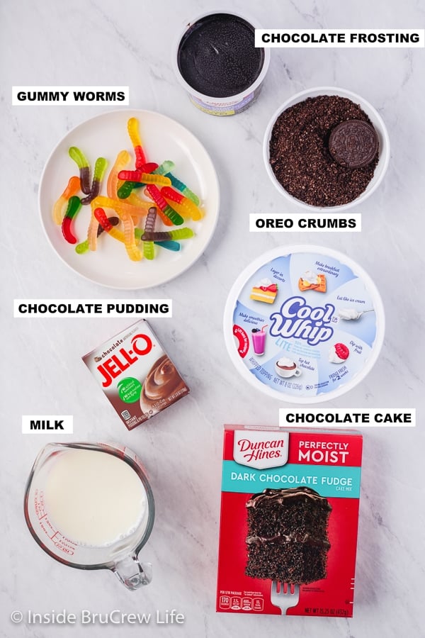 A white board with bowls of ingredients to make Pudding Filled Dirt Cupcakes.