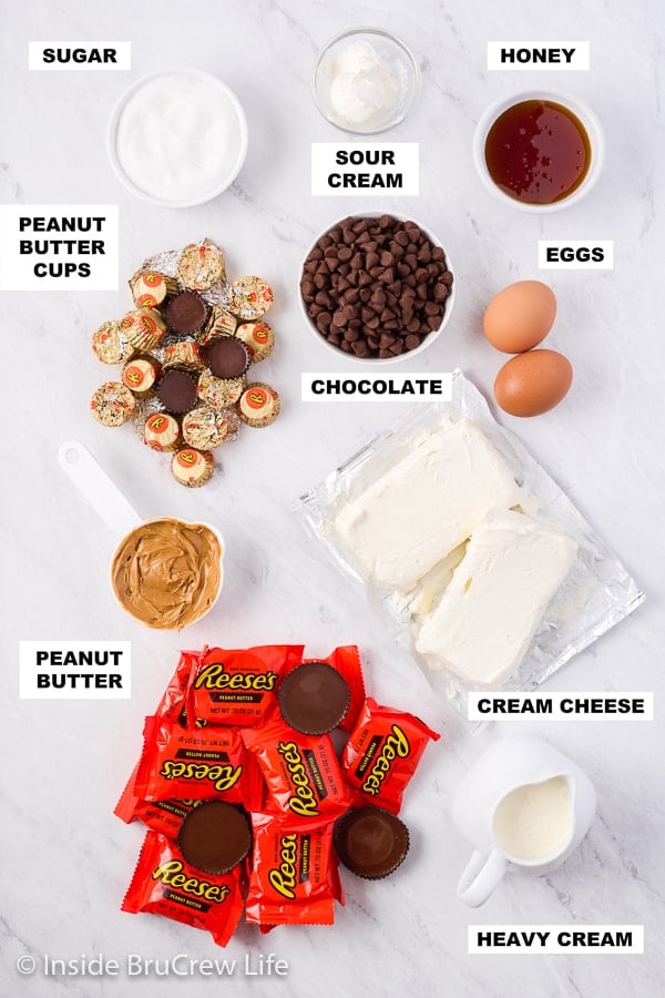 A white board with bowls of ingredients needed to make peanut butter cheesecake cupcakes.