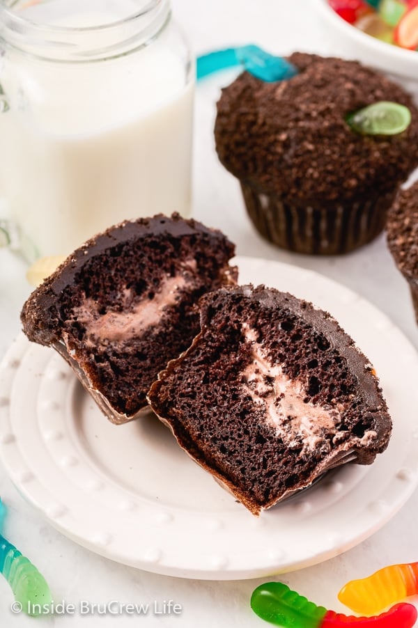 A white plate with a pudding filled dirt cupcake cut open showing the filling.