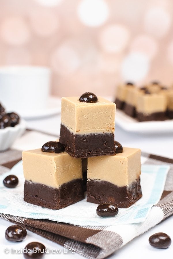 Three squares of fudge stacked on a paper.