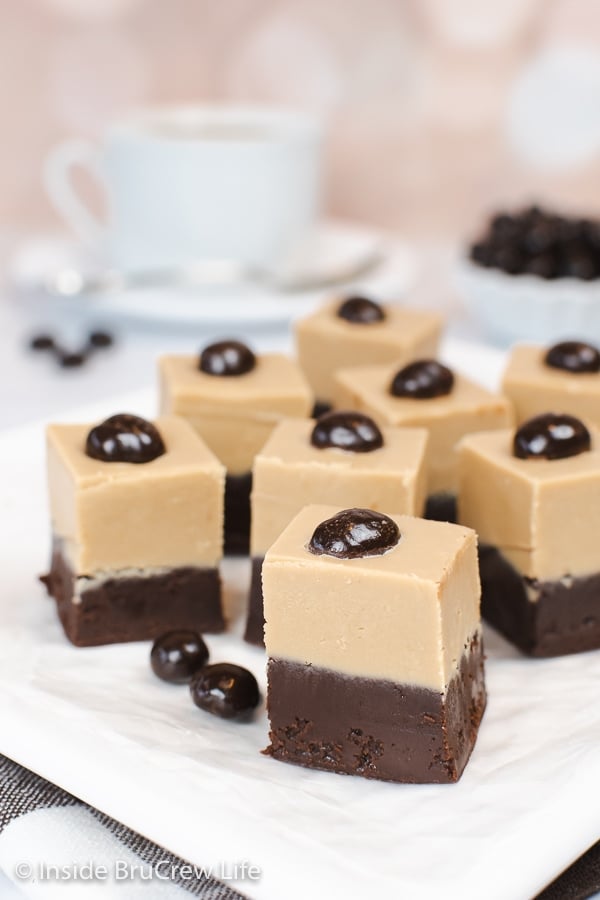 Squares of layered fudge on a white plate.