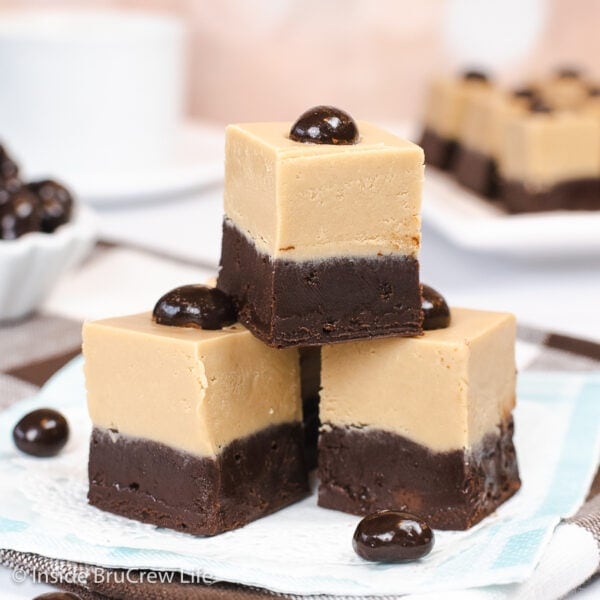 Three pieces of fudge stacked on a white plate.