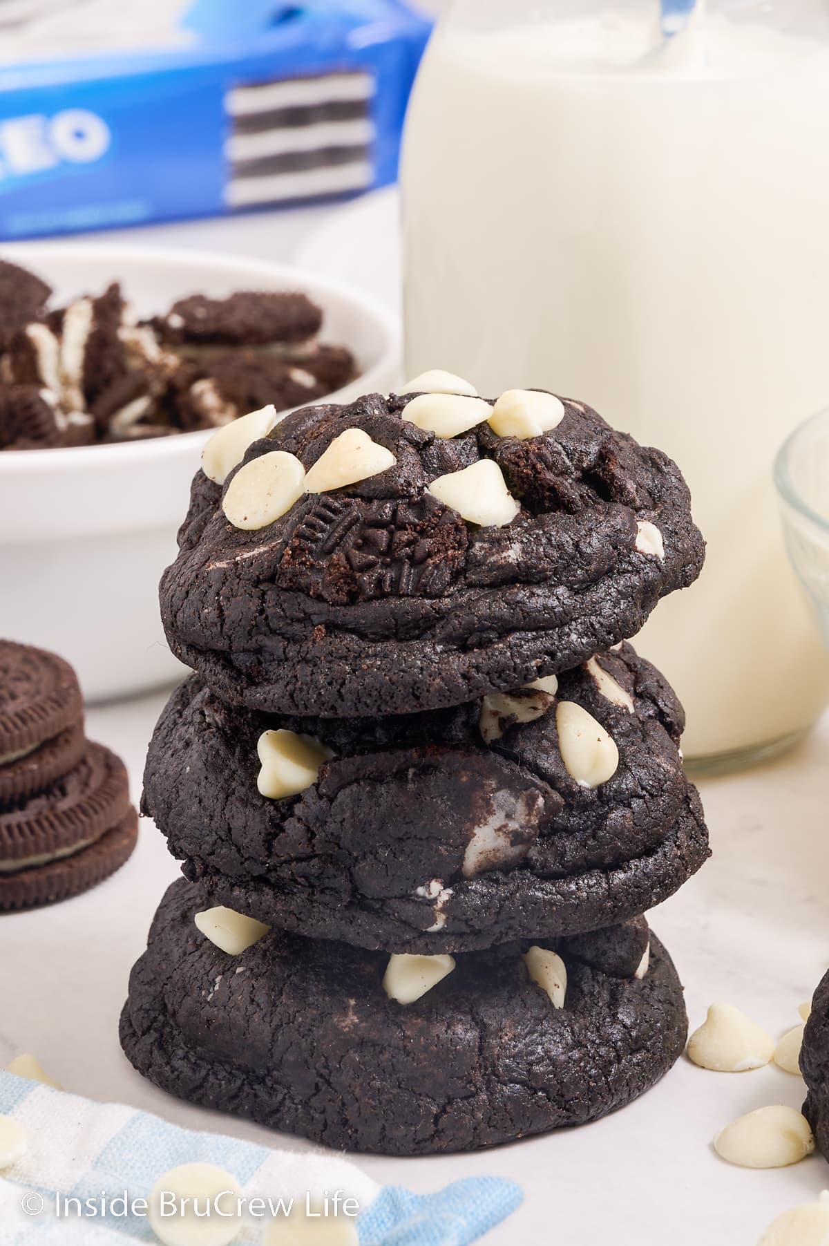 A stack of three oreo chunk cookies on a white board.