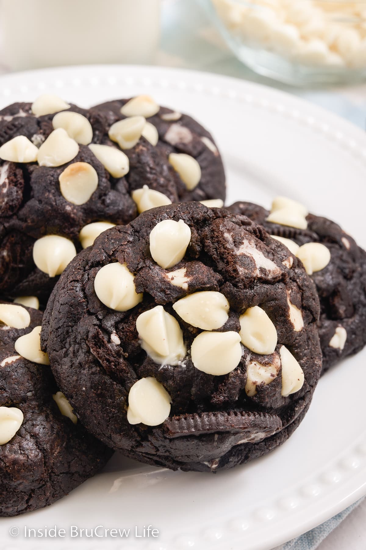 A stack of white chocolate Oreo cookies on a white plate.