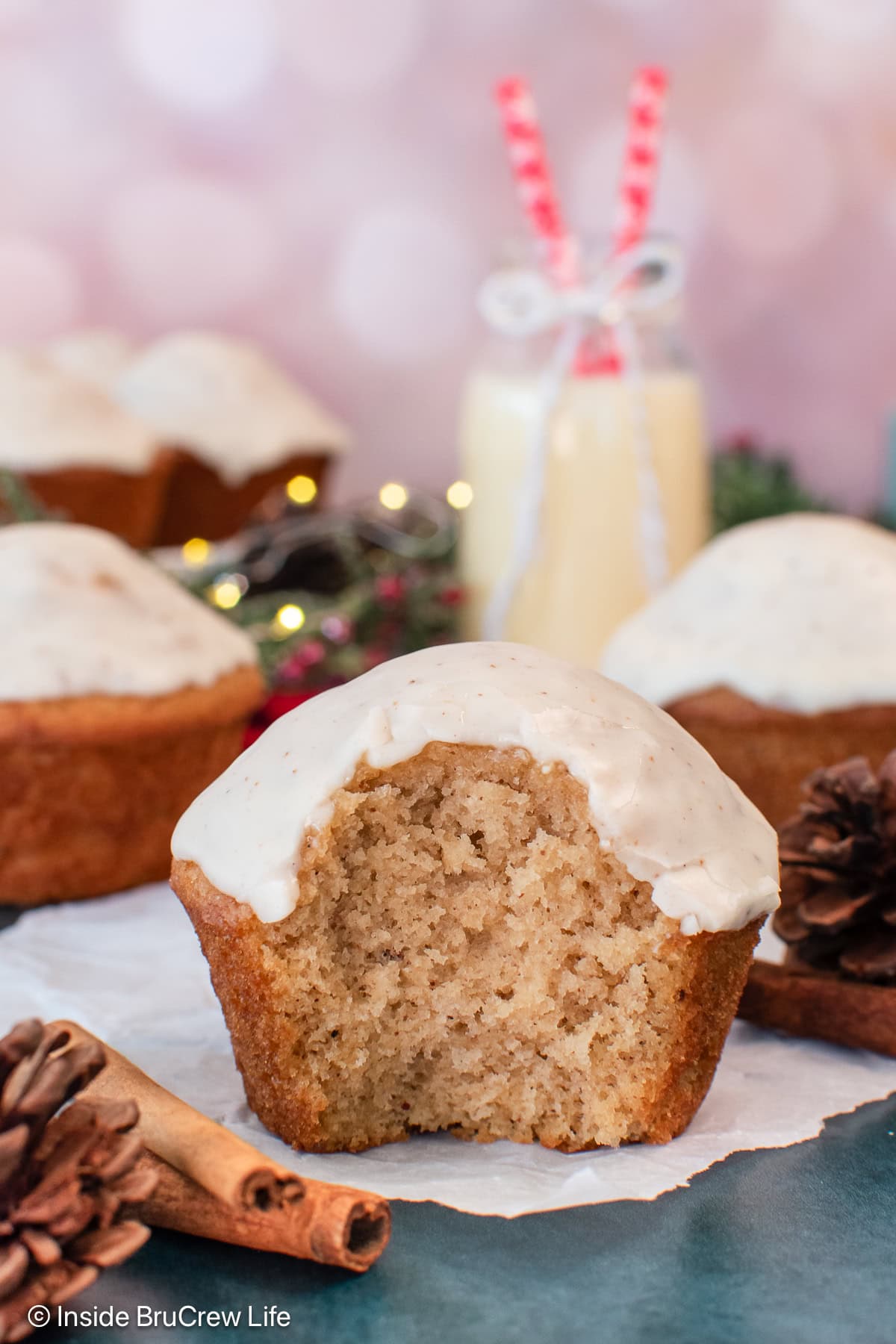 A fluffy glazed muffin on a piece of parchment paper.