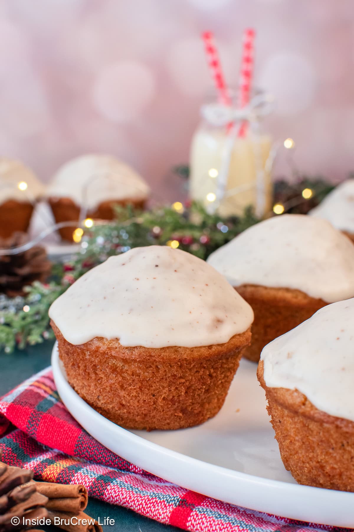 Glazed eggnog muffins on a white plate.