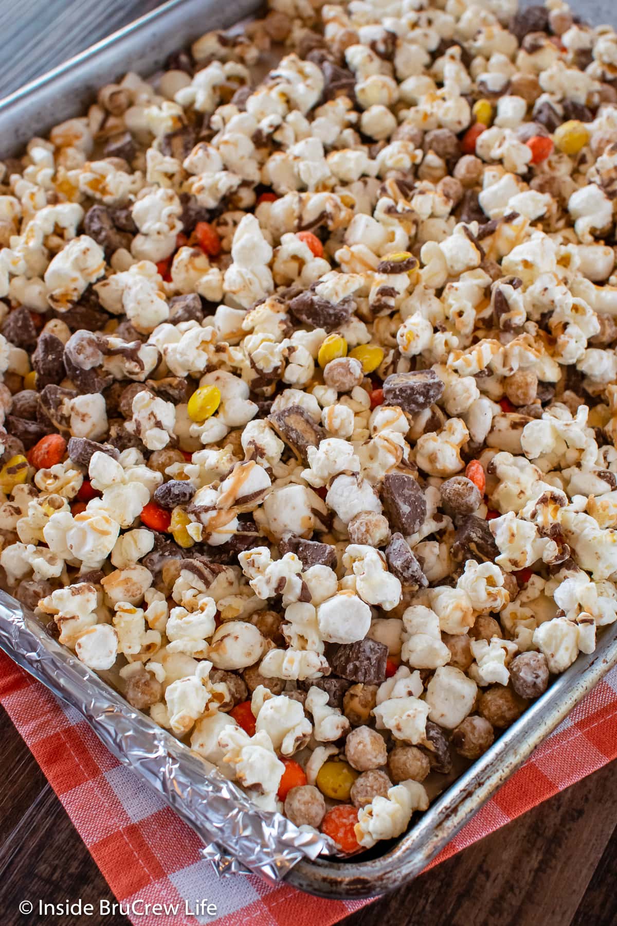 A silver sheet pan filled with popcorn and candy.