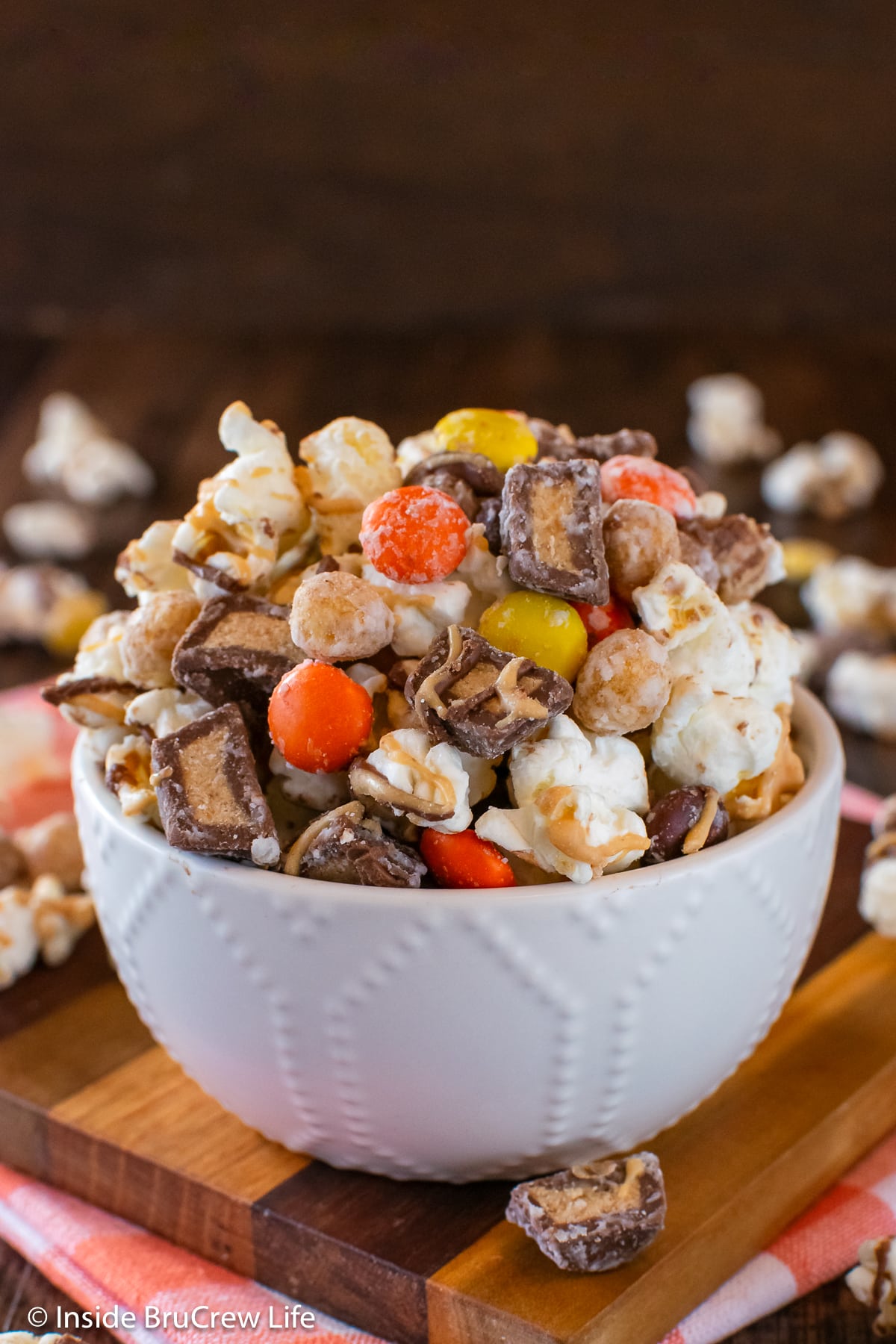 A white bowl filled with chocolate covered popcorn.