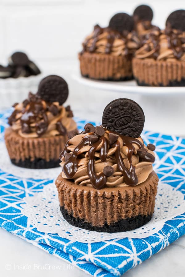 Mini Triple Chocolate Cheesecakes - these little tiny cheesecakes are loaded with three times the chocolate goodness. Hot fudge, chocolate chips, and cookies make this recipe even more chocolaty. #chocolate #cheesecake #chocolatelovers #Oreocookies #minidesserts #recipe #dessert