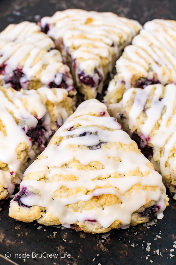 Baked blueberry scones with coconut drizzle on top.