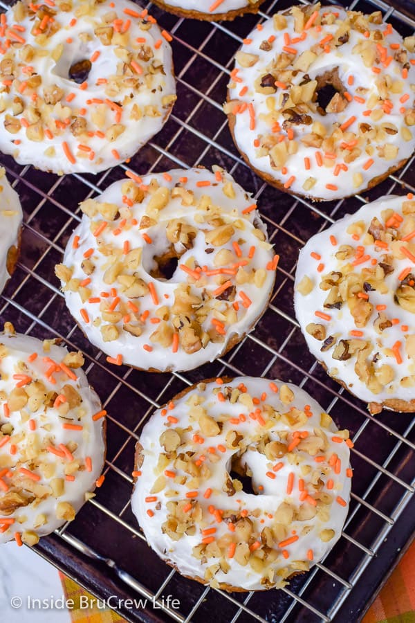 Overhead picture of frosted donuts on a wire rack.