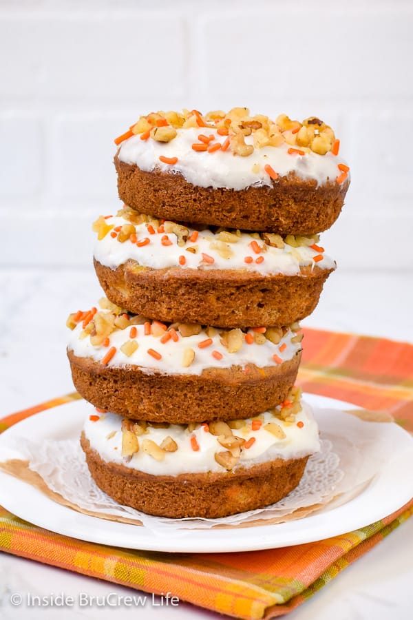 A stack of donuts on a white plate.