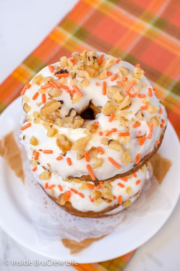 Overhead picture of a stack of donuts with white frosting and nuts on top.
