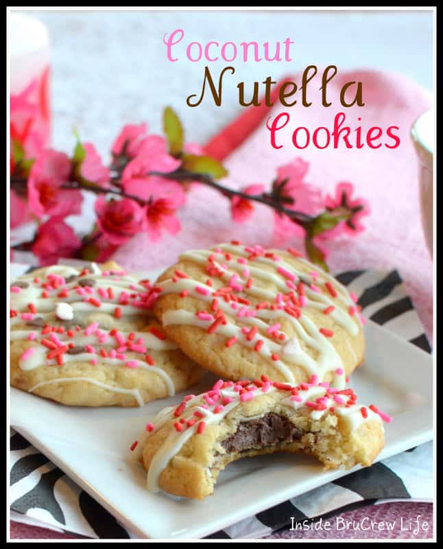 Three Coconut Nutella Cookies on a white plate with pink flowers in the background